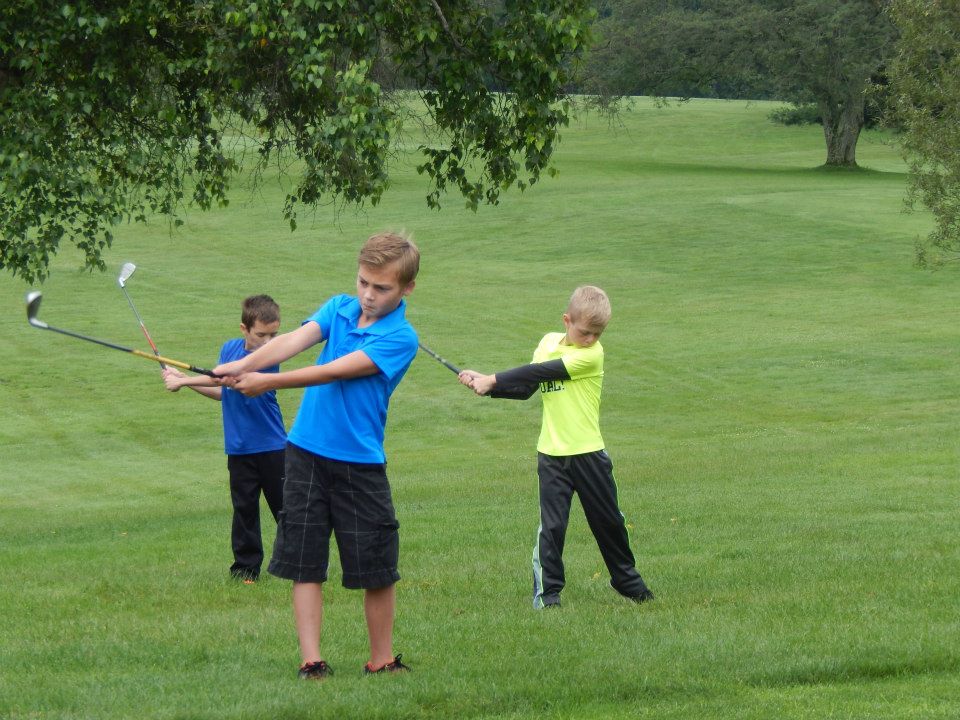Young golfers practicing their swings on a Twin Lakes fairway